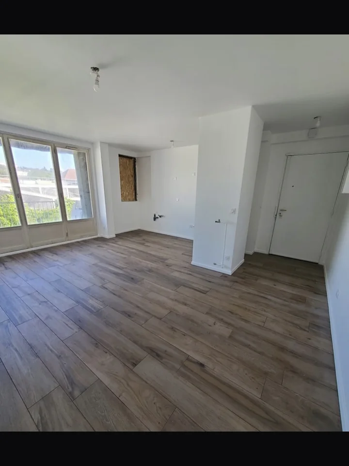 Après rénovation complète — séjour réhabilité carrelage imitation parquet murs blancs